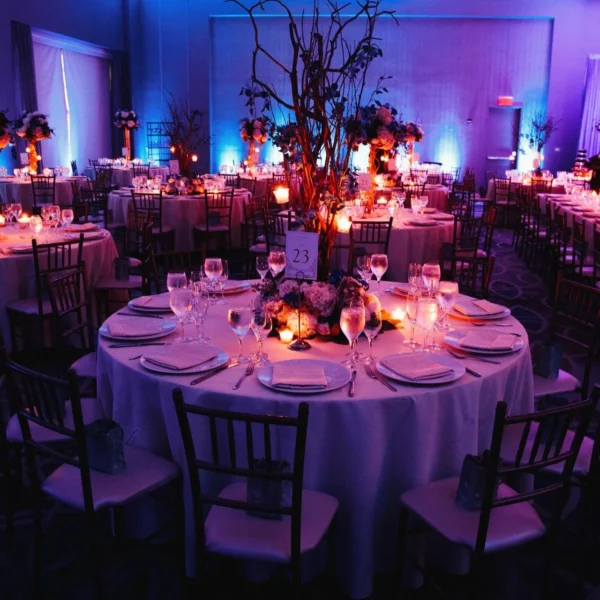 decorated-wedding-hall-with-candles-round-tables-centerpieces-min-1920x1280